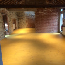 A new pine floor in the main entrance area after a mustard coloured finish.